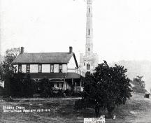 North elevation of the Gage House with the newly constructed monument ion the background; Hamilton Public Library, Special Collections