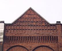 View of the pediment on the east elevation showing corbelling and emboss patterning – April 2003; OHT, 2003