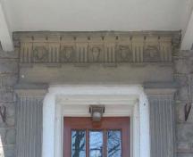 Fluted pilasters and decorated pediment displaying carved wreaths and a central lamb's head.; Lindsay Benjamin, 2007.