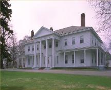 Corner view of the Government House in Charlottetown, showing the single-storey verandah, and its symmetrically organized elevations with evenly spaced multi-pane sash windows, 1989.; Parks Canada Agency / Agence Parcs Canada, 1989.