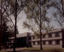 Vue de l'entrée principale de l'édifice O-109 (quartiers des sous-officiers), qui montre son plan symétrique et sa volumétrie d’où se dégage une impression d’horizontalité, 1992.; Department of National Defence / Ministère de la Défense nationale, 1992.