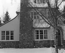 Façade de la résidence du directeur du parc, qui montre les fenêtres à petits carreaux de différentes tailles et formes et la cheminée en pierre des champs, 1989.; George A. Armstrong, 1989.
