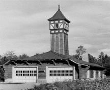 View of the Firehall, showing the intricate log construction, the timber ‘crib’ containing the garage, the curved hipped roof, and clearly illustrates the prominence of the tower.; Parks Canada Agency / Agence Parcs Canada, n.d.