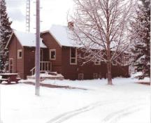 View of the Warden's Residence, showing the wood siding is finished in red-brown paint with light trim, 1992.; Parc national du Canada Banff / Banff National Park of Canada, 1992.