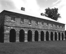 View of the front façade of the Guardhouse, showing the architectural composition of the building, which consists of a rectangular plan, arcaded portico and hipped roof.; Parks Canada Agency / Agence Parcs Canada.