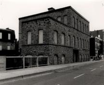 Vue de l'usine est, qui montre la disposition régulière des portes et les fenêtres régulièrement espacées, 1972.; Agence Parcs Canada / Parks Canada Agency, 1972.