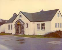 Vue générale du bureau de l'administration, qui montre la façade agencée symétriquement avec un porche en pierre central qui abrite l’entrée principale, 1990.; Parks Canada Agency / Agence Parcs Canada, 1990.