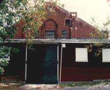Exterior view of RMC Building 3, showing the former tack shed at the west end, 1993.; Parks Canada Agency / Agence Parcs Canada, 1993.