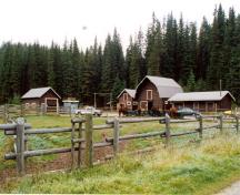 Panorama du nord-ouest montrant les pâturages et les quatre bâtiments d'exploitation à Yoho Ranch, y compris l'écurie (deuxième bâtiment de la droite), 1999.; Cultural Resource Services, Calgary, 1999.