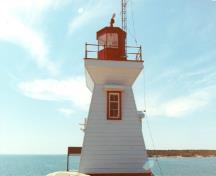 Vue générale du Phare, qui montre la passerelle carrèe avec le garde-corps et la lanterne proéminente octogonale, 1990.; Canadian Coast Guard / Garde côtière canadienne, 1990.