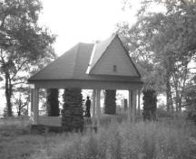 General view of the Gordon Island Pavilion, showing the decorative exposed rafter ends and the low wooden railing, 1992.; Archeological Services and Historica Resources Ltd., 1992.