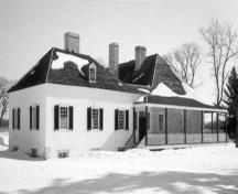 Side view of the Big House, showing the colombage pierroté of the annex, which consists of a heavy oak timber frame infilled with rubblestone and mortar and finished in stucco, 1989.; Parks Canada Agency / Agence Parcs Canada, K. MacFarlane, 1989.