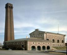 View of the Hamilton Waterworks complex, showing the tall chimney and the distinctive Italianate profile of the original waterworks pumphouse, 1993.; Parks Canada Agency/Agence Parcs Canada, 1993.