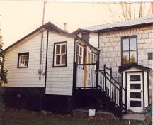 General view of the east façade and veranda of the Defensible Lockmaster’s House, 1987.; Parks Canada Agency / Agence Parcs Canada, 1987.