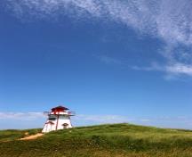 Vue générale du phare de Covehead Harbour montrant son emplacement le long des dunes du parc national de l’Île-du-Prince-Édouard, sur la plage située tout juste à l’est de l’entrée de la baie Covehead; Parks Canada Agency | Agence Parcs Canada