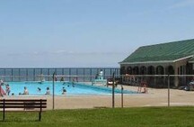 View of the Saltwater Pool and Bathhouse, showing its unobstructed view of the Bay of Fundy.; Parks Canada Agency / Agence Parcs Canada.