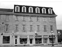 Façade of the Commercial Building, showing the plan of the principal elevation on Sussex Drive that has three ground floor entrances, and three shop windows, 1986.; Parks Canada | Parcs Canada, D. Johnson, 1986.
