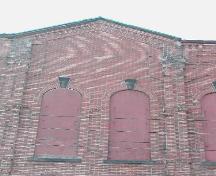 This photograph shows the roof-line in the center of the façade.; City of Saint John 2004