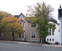 North facade of Emmanuel House bordered by Bannerman and Cochrane Streets.  The Cochrane Street United Church can be seen directly behind the house, on the right (white building with red/brown squares, triple lancet windows). ; HFNL/ Deborah O'Rielly 2006.