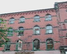This photograph shows the upper storeys and cornice and illustrates the decreasing height of the windows on each floor, 2004; City of Saint John