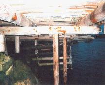 View of underside showing wood post foundation, Roland Chippett Stage, Leading Tickles, 2004. ; HFNL 2007