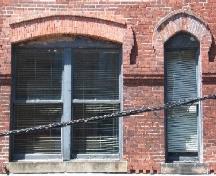 This photograph shows a double window and some of the brick design, 2005.; City of Saint John