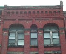 This photograph shows the cornice with corbel bands and the large pilasters, 2005.; City of Saint John