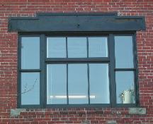 This image provides a view of the large, central, second storey window with a wood lintel and brick sill, 2005.; City of Saint John