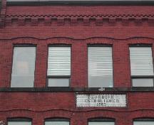 This photograph shows the cornice and upper storey windows on the Prince William Street façade. Also visible is the Dearborn sign, 2005; City of Saint John