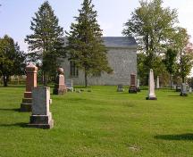 Side view showing stone filled window and cemetery-2006; OHT, 2006