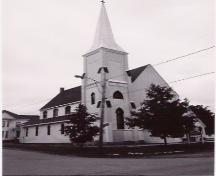 This image shows the asymmetrical façade and Gothic windows of the church.; Province of New Brunswick