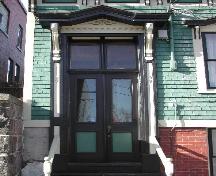 This photograph shows the double wooden door with glass panel and transom window, 2005  ; City of Saint John