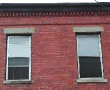 This photograph shows the dentils at the roof-line cornice and the two upper storey windows, 2005; City of Saint John