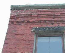 This photograph shows the cornice, with small corbel bands, and illustrates a sandstone lintel, 2005; City of Saint John