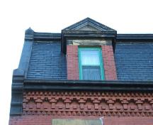 This photograph shows a dormer window, the roof-line cornice with dentils and decorative frieze band, 2005; City of Saint John