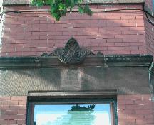 This photograph shows the protruding carving over a lower storey lintel, 2005; City of Saint John
