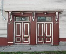 Cette photographie montre les entrées doubles de l'édifice, les impostes, et l'entablement à consoles ornées, 2005; City of Saint John
