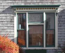 Cette photographie montre la fenêtre triple avec entablement à consoles orné de dentelets. Elle montre aussi le panneau supérieur central en verre de plomb, 2005; City of Saint John
