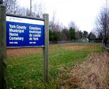 York County Municipal Home Cemetery surrounded by a chain link fence and identified with prominent signage; City of Fredericton