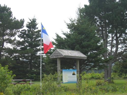 Signage and Acadian flag by the highway