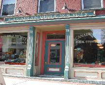 This photograph shows the storefront cornice and the placement of the sign as well as the recessed entranceway and pilastres, 2004; City of Saint John