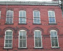 This photograph shows the window design, the ledge that runs through the second storey, and the roofline cornice, 2004; City of Saint John 