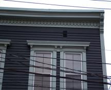 This image shows the ornamental woodwork of the brackets, the cornice and the lintels; City of Saint John