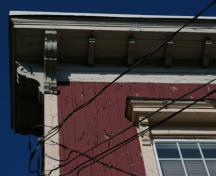 This image shows the cornice with exposed rafter tails end brackets; City of Saint John