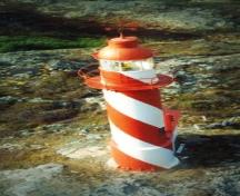 General view of the Bacalhao Island Lighttower showing the spiraling daymark colours extending up into the lantern’s murette.; Department of Fisheries & Oceans Canada/Département de pêches et océans Canada