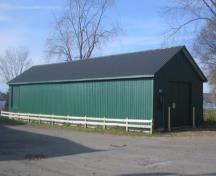 Side view of former internment camp building, showing elongated footprint and medium pitched roof.; City of Fredericton
