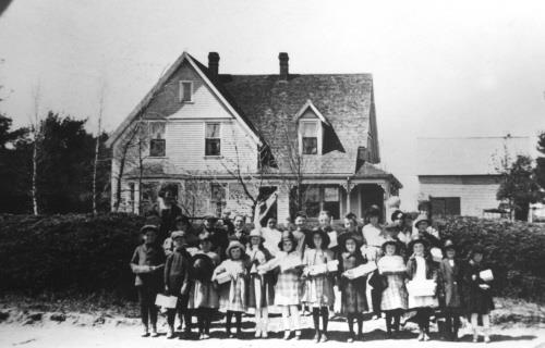 House with group of children, c. 1910