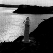 General view of the lighttower at King's Cove Head, showing the overall composition and appearance of the lighthouse isolated on a headland jutting into a bay on the exposed Newfoundland coast, 1989.; Canadian Coast Guard/Garde côtière canadienne, 1989.